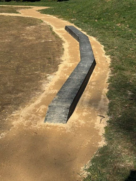 Poutre en courbe VTT en plastique recyclé utilisée comme obstacle d’équilibre sur un parcours technique