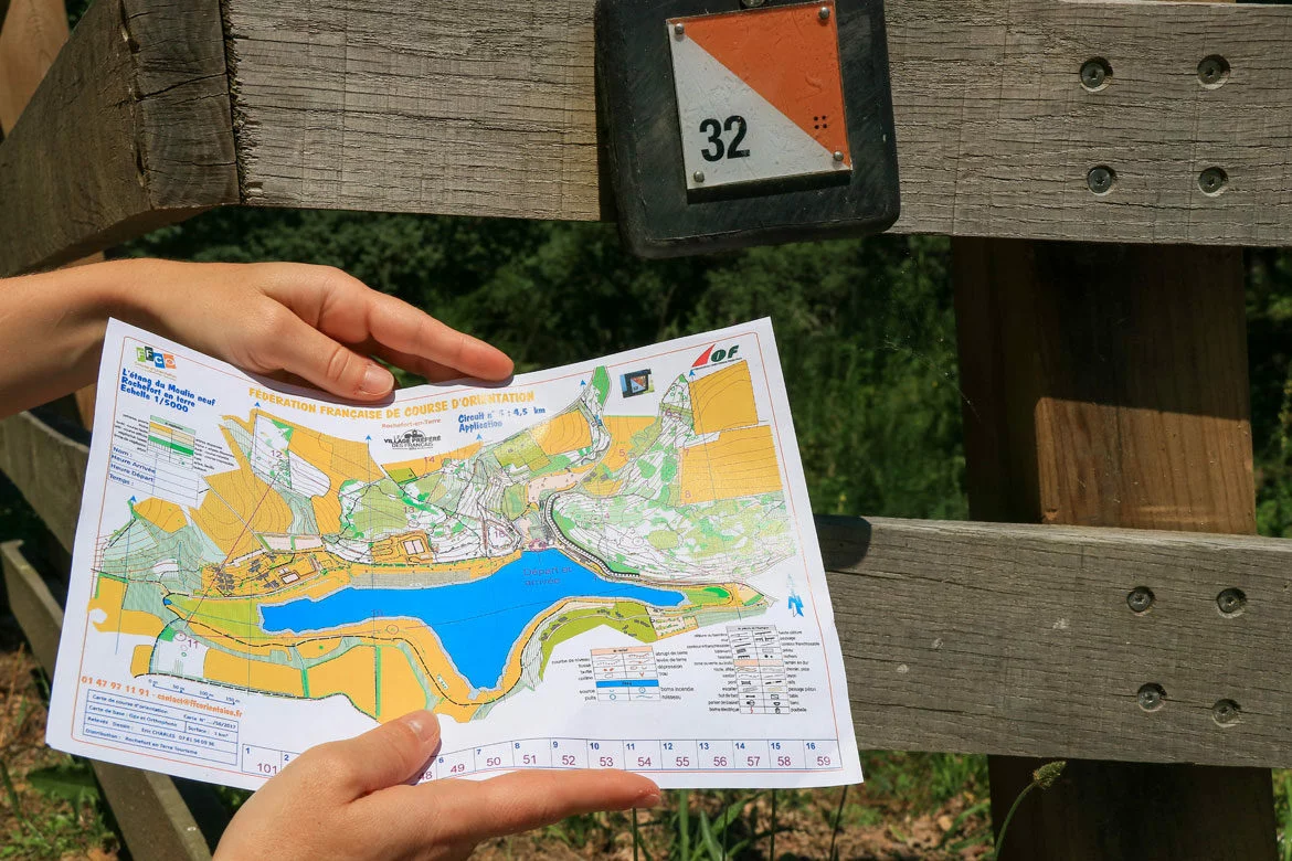 Carte de course d’orientation et boîtier de poinçonnage installés sur parcours permanent d’orientation