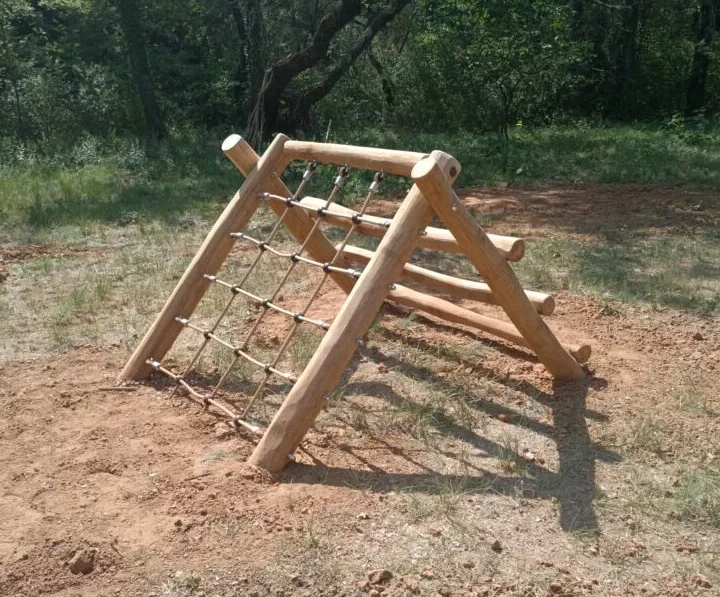 Échelle oblique avec filet sur un parcours de motricité pour enfants en extérieur